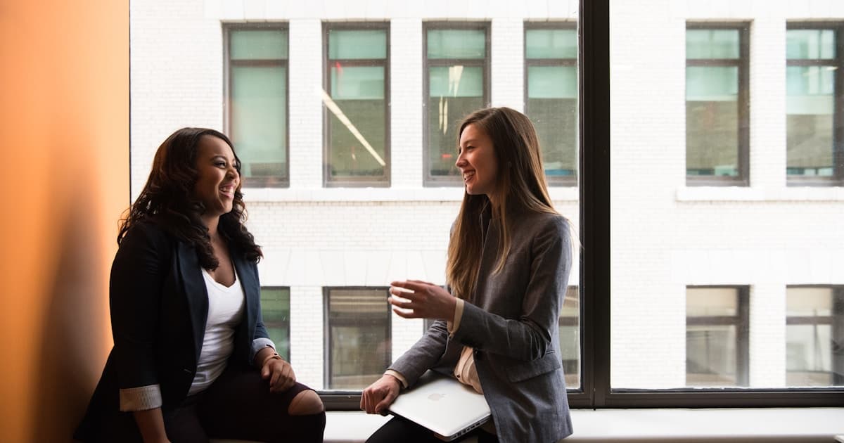 Two business professionals in conversation in a modern office - representing a smooth IT provider transition managed by ITstuffed